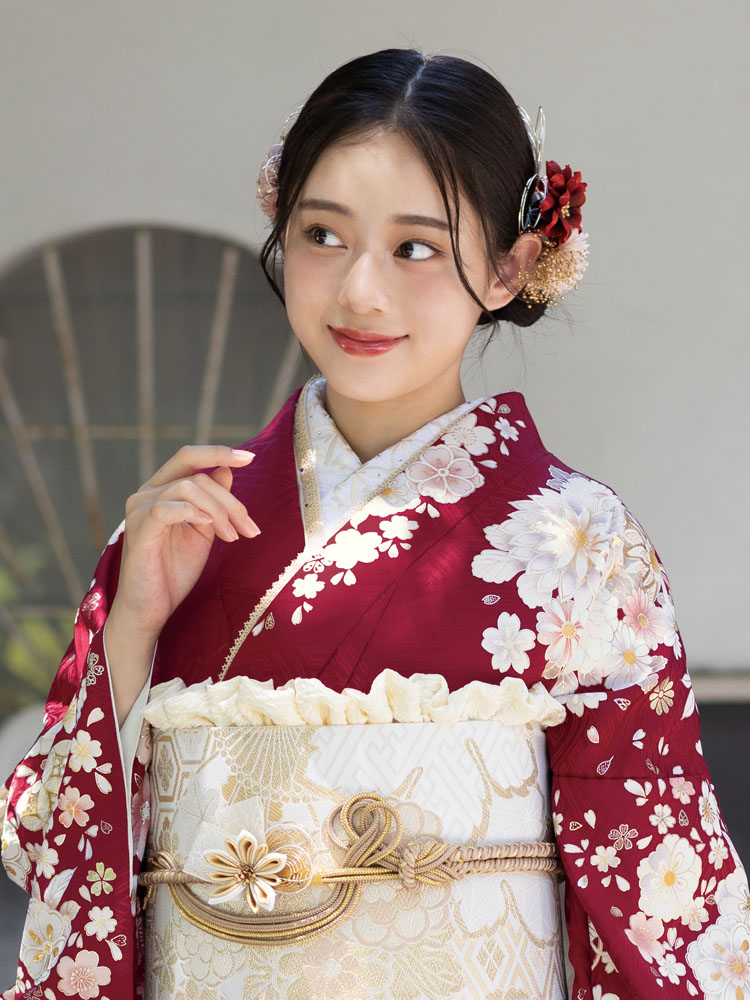 深紅の地に白や金の花々が華やかに広がる振袖。