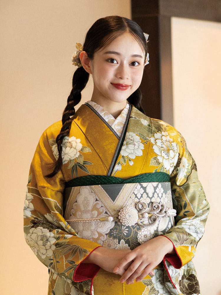 山吹色と若草色が調和した地に、白や金の花々が咲き誇る振袖。