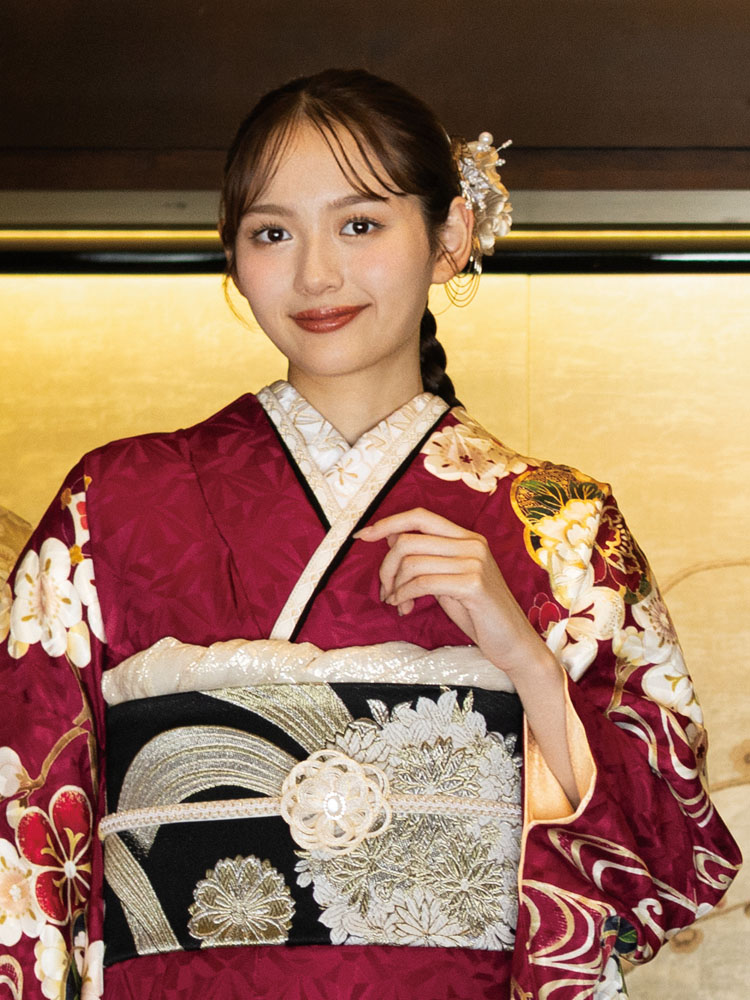 深紅の地に梅や菊、桜などの花々が雅やかに描かれた振袖。