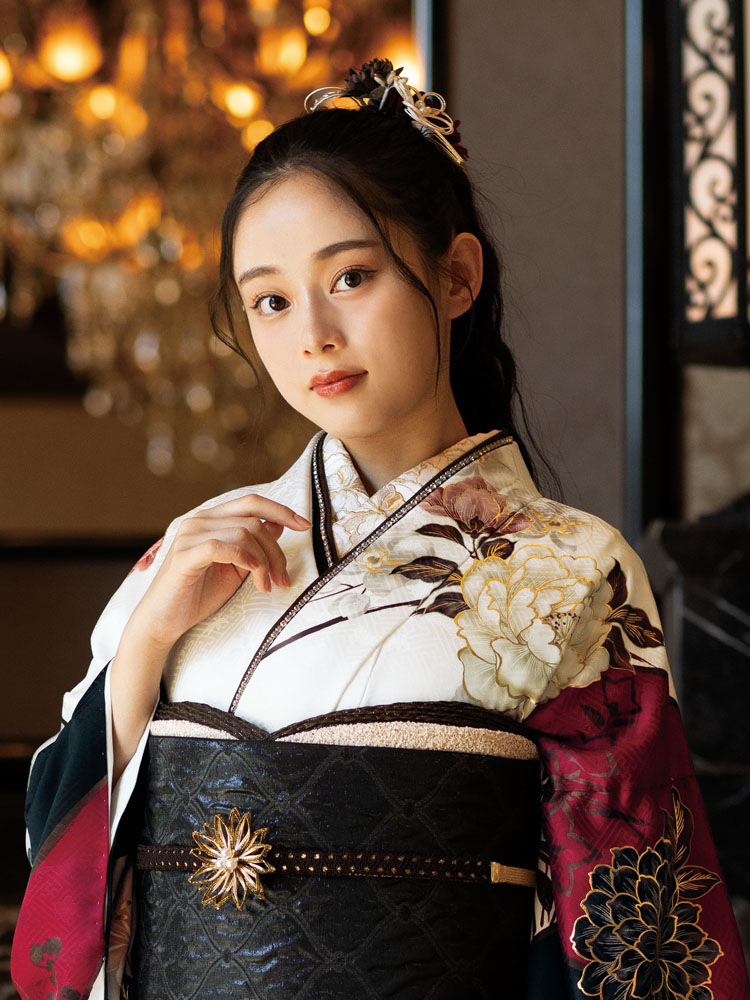 白地に深紅と黒の切り替えがモダンに映え、大輪の花々が優美に彩る振袖。