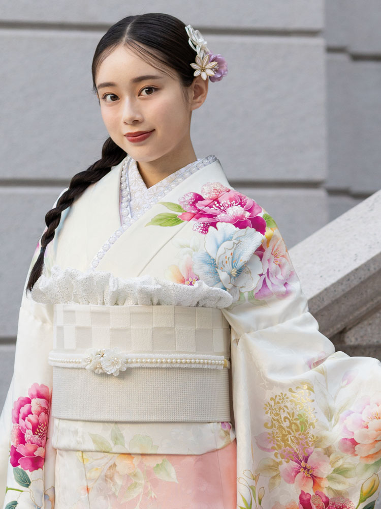 白地に柔らかなピンクが溶け合い、大輪の花々が華やかに咲き誇る振袖。